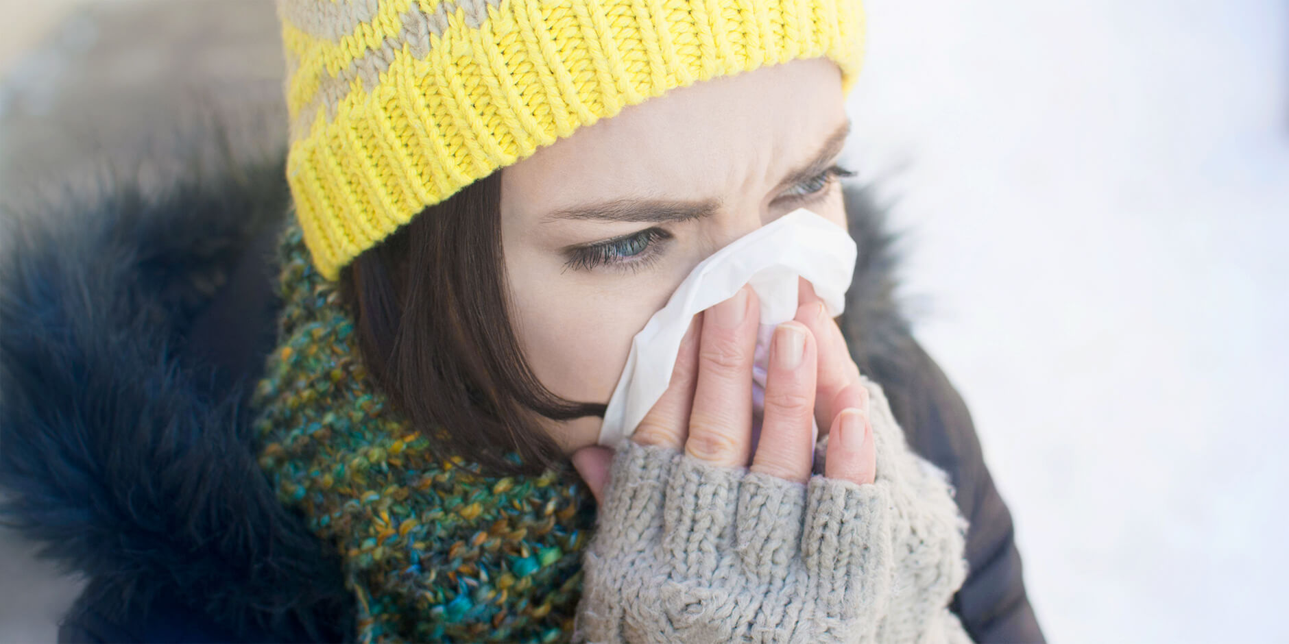 Femme en vêtements d'hiver en train de se moucher
